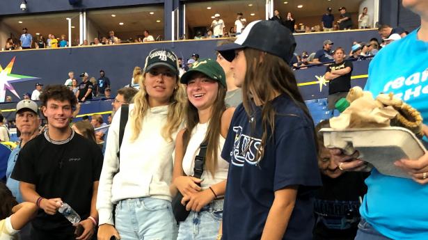 Students at Tampa Bay Rays baseball game standing in front of seats.
