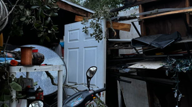 A home by Second Heart Homes shows damage from hurricane - wooden cabinet, mo-ped, everything in a pile together.