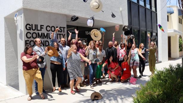 People gather outside Gulf Coast's Sarasota Philanthropy Center and throw their hats in the air celebrating graduation from Gulf Coast Leadership Institute.