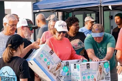 People helping distribute boxes of baby wipes after Hurricane Milton.