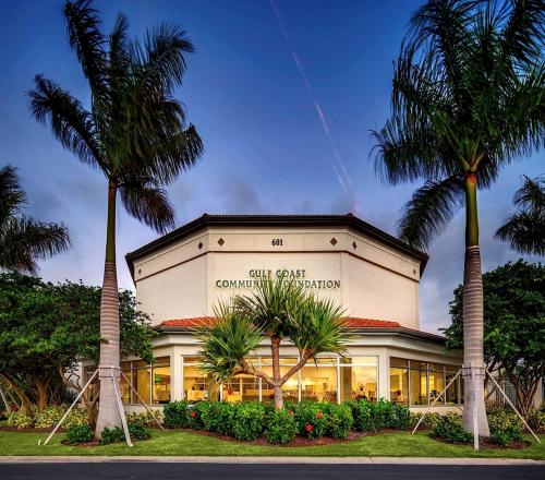 Photo of the front of Gulf Coast Community Foundation's Venice Headquarters with palm trees.