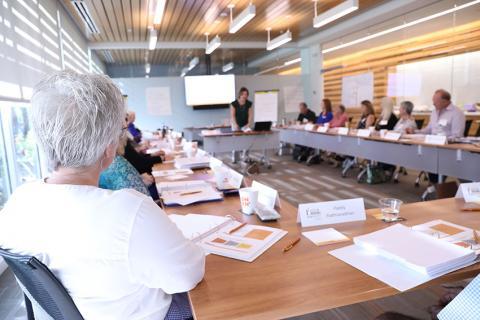 People sitting around table at Gulf Coast Community Foundation's Venice Headquarters. Speaker standing at front of room.