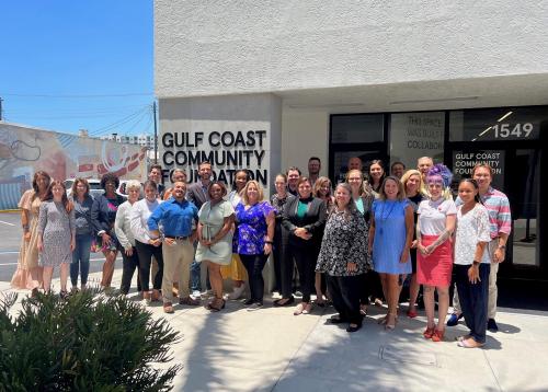 About 15 people stand outside of Gulf Coast Community Foundation's Sarasota Philanthropy Center.