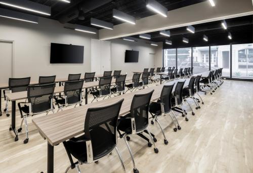 Inside Room One and Two of The Sarasota Philanthropy Center - two tvs on wall, chairs, tables