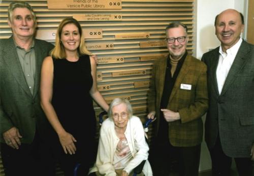 Five people smiling at camera. One woman in wheelchair.