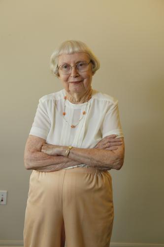 One woman with short grey hair and peach colored pants looks at camera.