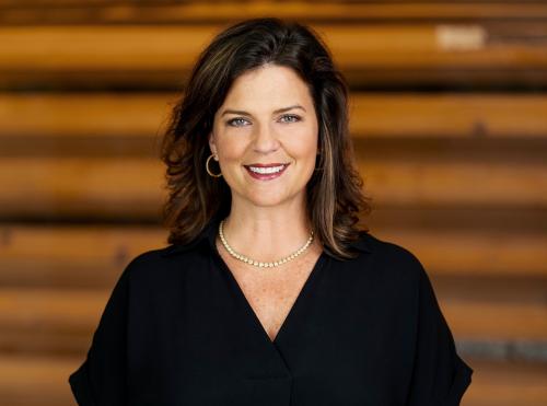 Dr. Kameron Partridge Hodgens with Gulf Coast Community Foundation smiles, looks at camera, in her headshot wearing black shirt.