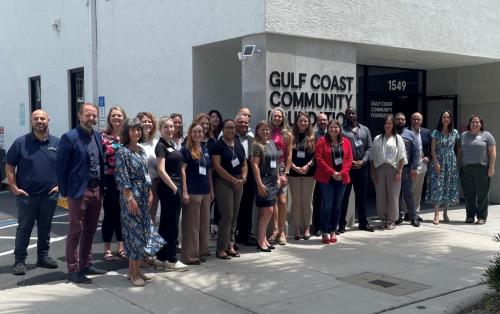 About 25 people stand outside of Gulf Coast's Sarasota Philanthropy Center.