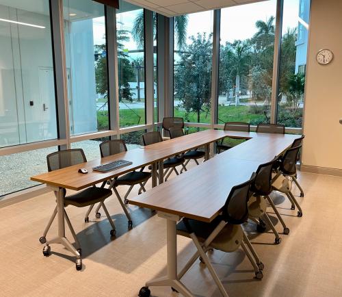 A bright room with one long table and chairs.