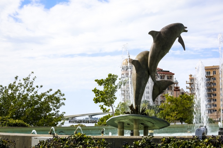 A statue of dolphins in front of a fountain.