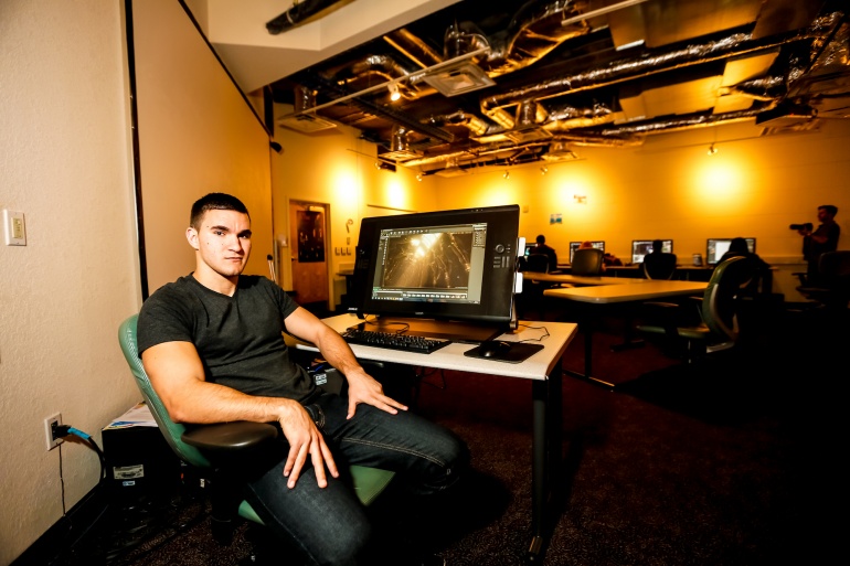 Man seated by desk with computer and glowing bulbs